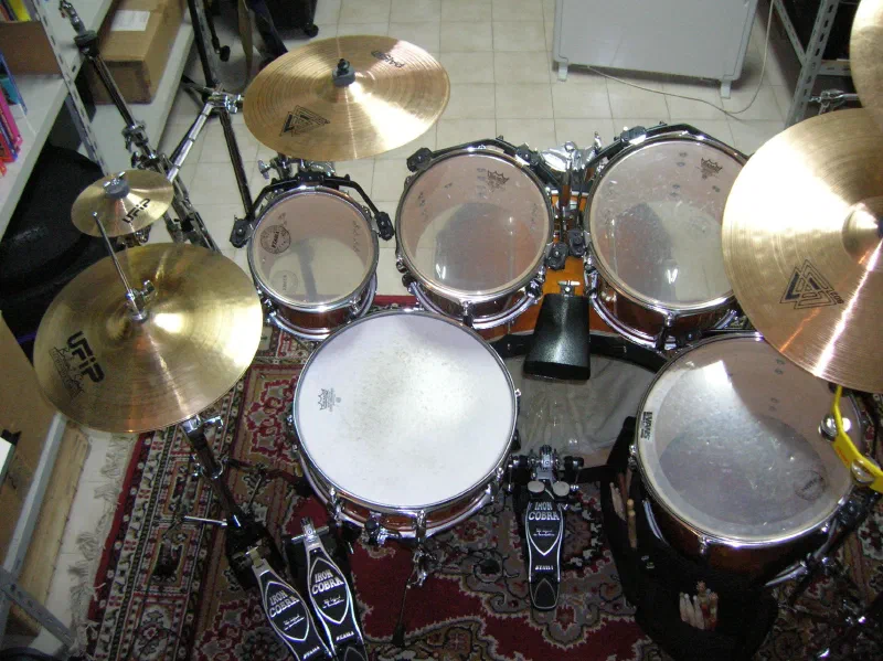 Overhead view of a drum kit with UFIP cymbals and a double bass drum pedal on a rug