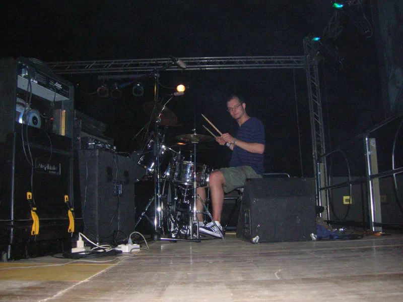 Fabio D’Amico at the drums on a dark, empty stage