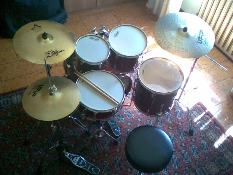 Drum kit with Zildjian cymbals and a drum throne, seen from above in a sunlit room
